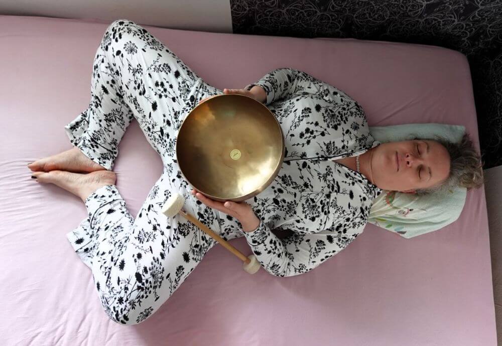 Yin Yoga bei Schlaflosigkeit liegender Schmetterling Person liegt in der Yin Yoga Asana der liegende Schmetterling zu Thema - Yin Yoga bei Schlafstörungen